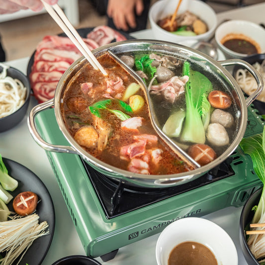 A stainless steel pot filled with different hot pot ingredients